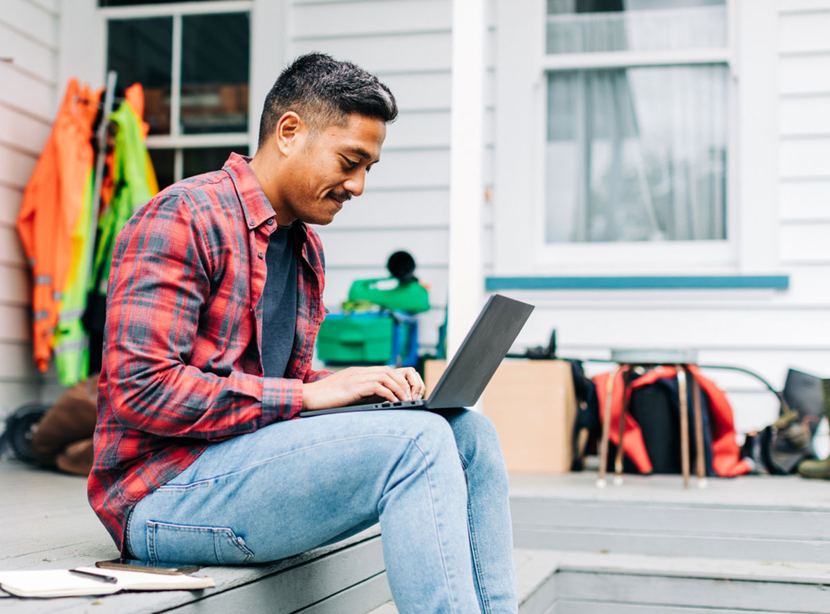 man using laptop on deck 