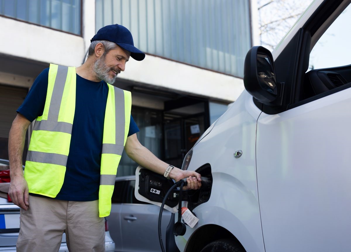 man in high vis charging electric van 1200x860 